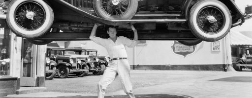 Man lifting pre war car over his head