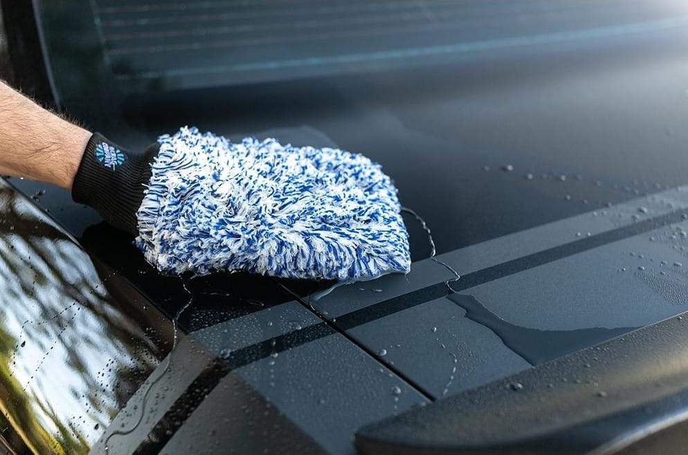 cleaning a car with a wash mitt